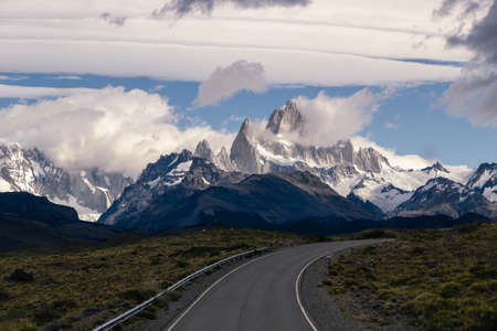 Asphalted road with the peaks of a rocky and snowy mountain on the horizon. Fitz Roy mountain in Argentina vertical Photographの写真素材