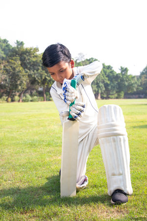 Confident boy wearing cricket uniform and playing Cricket