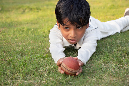 Boy catching cricket ball in the groundの写真素材