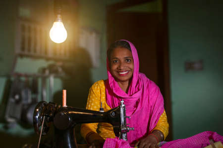 PORTRAIT OF A RURAL WOMAN SEWING CLOTHESの写真素材
