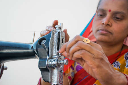 CLOSE-UP RURAL WOMAN using sewing machineの写真素材