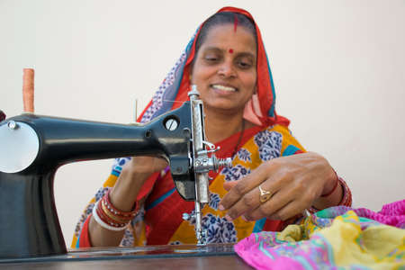 woman on a sewing machine making clothes in a rural indian villageの写真素材