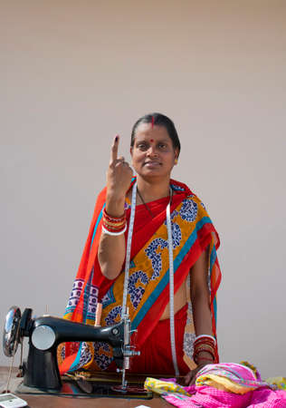 PORTRAIT OF A RURAL WOMAN voters mark on finger with sewing machineの写真素材