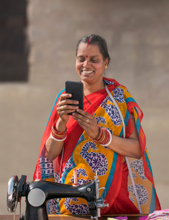 Happy RURAL WOMAN Holding Mobile while reading text messageの写真素材