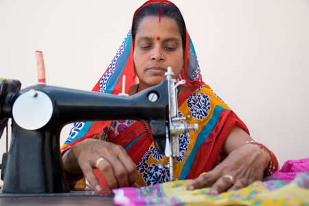 PORTRAIT OF A RURAL WOMAN STITCHING CLOTHESの写真素材