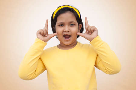Portrait of smiling girl gesturing thumbs upの写真素材