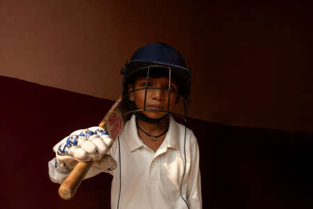 Portrait of boy wearing cricket Helmet and holding Batの写真素材