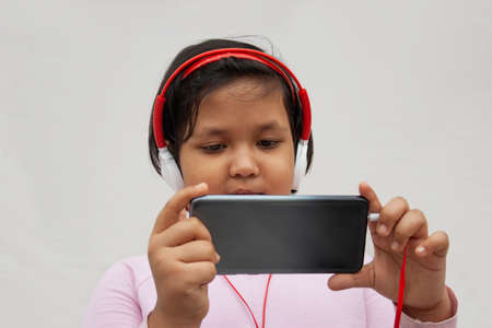 Close-up Girl Listening Music While Using Smart Phoneの写真素材
