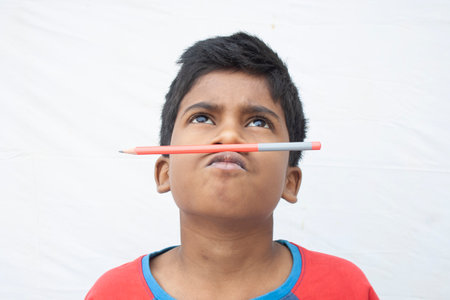 girl using a pencil as pretend moustacheの写真素材
