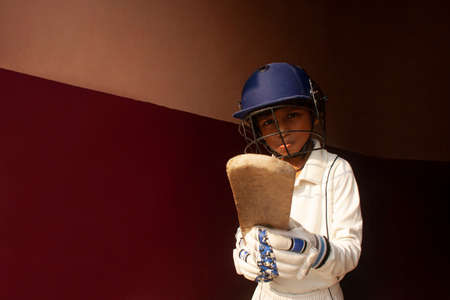 Portrait of boy wearing cricket Helmet and holding Bat