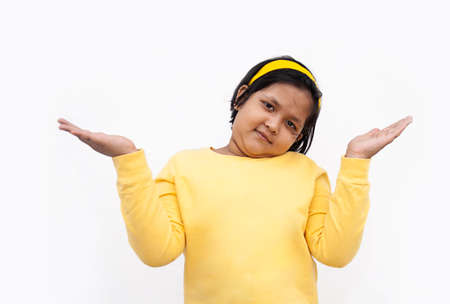 Portrait Of Girl With Arms Raised While Standing Against White Backgroundの写真素材
