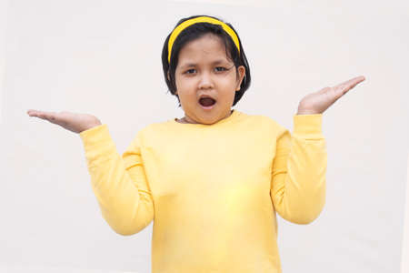 Portrait Of Girl With Arms Raised While Standing Against White Backgroundの写真素材