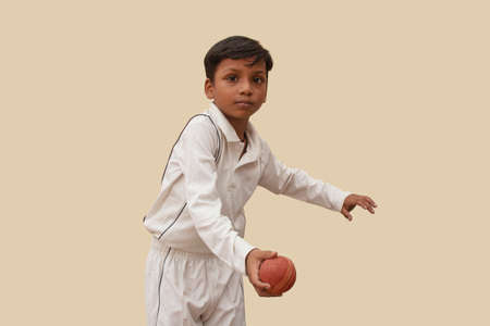 A boy Delivering a spin ball During a Cricket Gameの写真素材