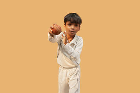 A boy Delivering a spin ball During a Cricket Gameの写真素材