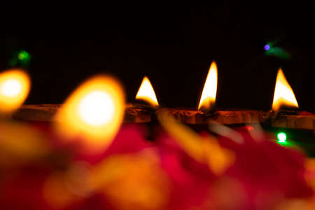 Group of decorated diyas on black background during Diwali