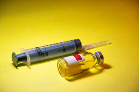 virus vaccine with syringe isolated on Yellow backgroundの写真素材