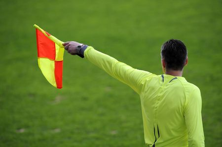 Referee signaling from the sidelines of a soccer game