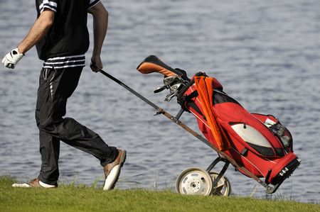 Golf player walks with golf clubs bag の写真素材