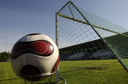 Soccer goal and ball in football stadiumの写真素材