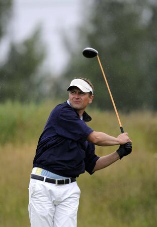 a golfer holding his finish after tee shotの写真素材