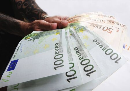 Hand holding a set of euro bills isolated on whiteの写真素材