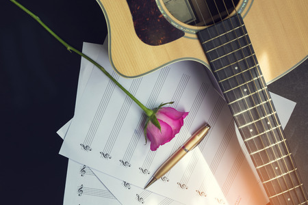Guitar with pen and rose on the note book,vintage filterの写真素材