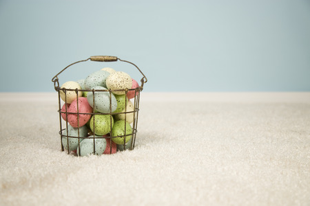 Multi-colored easter eggs in an antique wire basket