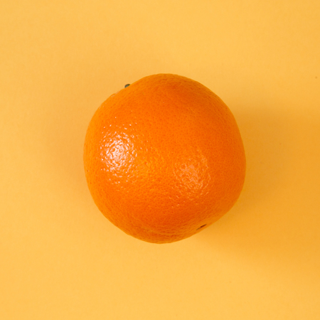 Orange Dramtically Lit on a Yellow Background