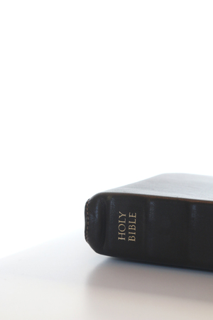 Simple Closed Holy Bible on a White Table and a White Backgroundの写真素材