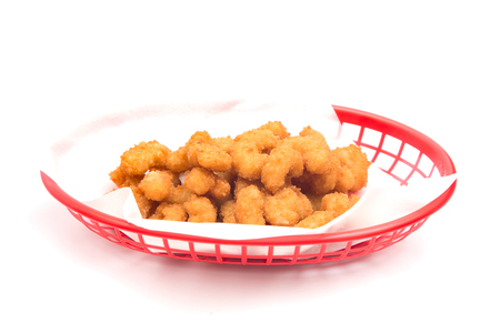 Battered and Fried Popcorn Shrimp in a Basket on a White Backgroundの写真素材