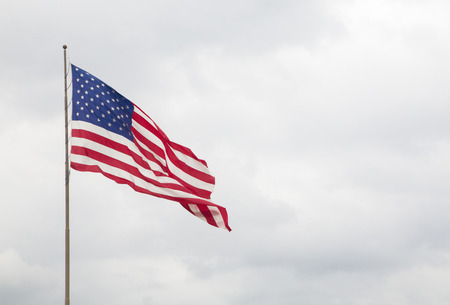 American Flag with a Blue Cloudy Skyの写真素材
