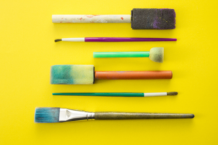Children's Paint Brushes on a Yellow Backgroundの写真素材
