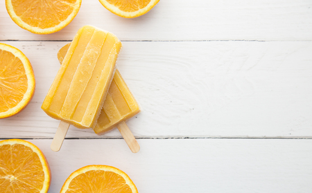 Orange Juice ice pop on a White Wood Tableの写真素材