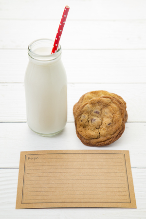 Milk and Cookies on a White Wood Table with a Recipe Card - Add Your Own Family Recipeの写真素材