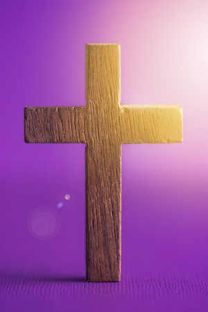 A Simple Wooden Cross on a Purple Backgroundの写真素材