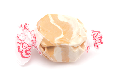 Single Piece of Brown and White Salt Water Taffy on a White Backgroundの写真素材