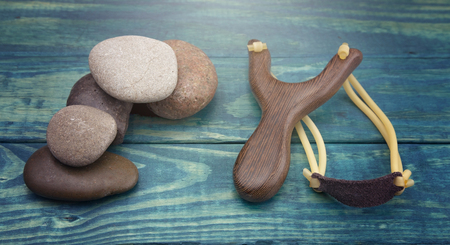Slingshot and Five Smooth Stones on a Blue Tableの写真素材