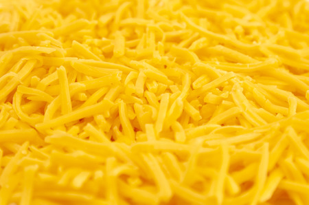 A Background of Grated Orange Cheddar Cheeseの写真素材