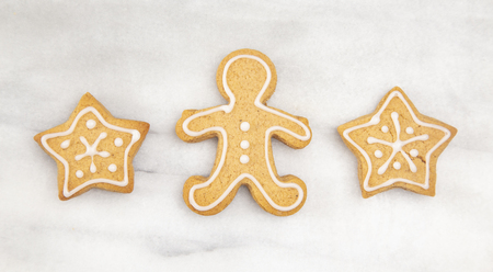 Three Gingerbread Cookies in a Row on a Marble Counter