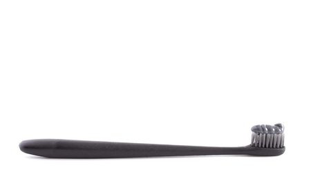 Black Toothbrush with Black Activated Charcoal Toothpaste on a White Backgroundの写真素材