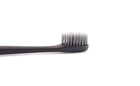 A Black Toothbrush without Toothpaste on a White Backgroundの写真素材