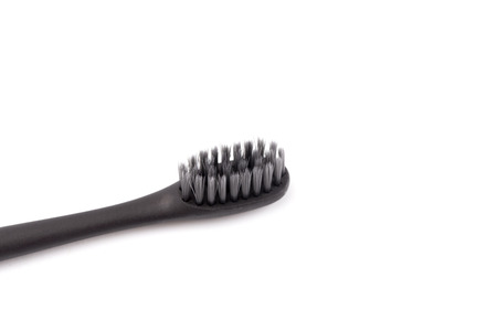 A Black Toothbrush without Toothpaste on a White Backgroundの写真素材