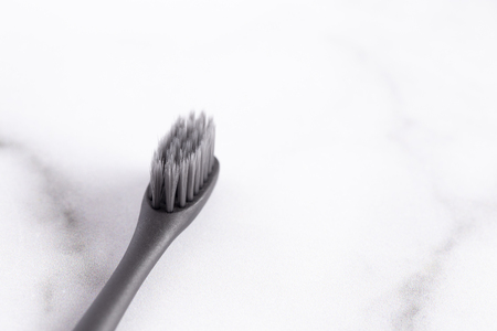 A Black Toothbrush without Toothpaste on a Marble Counterの写真素材