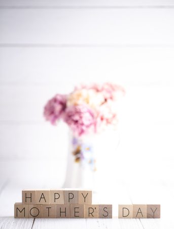 Mothers Day Background with Writing on Block Letters with Pink Flowers in a Vaseの写真素材