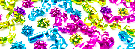 A Background of Party Ribbons and Bows in Bright Colors on White