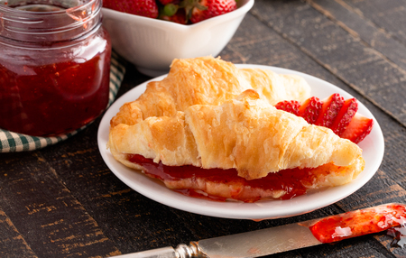 Croissants Filled with Fresh Homemade Strawberry Jam on a Wooden Tableの写真素材