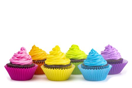 Rainbow Colored Frosted Chocolate Cupcakes Isolated on a White Backgroundの写真素材
