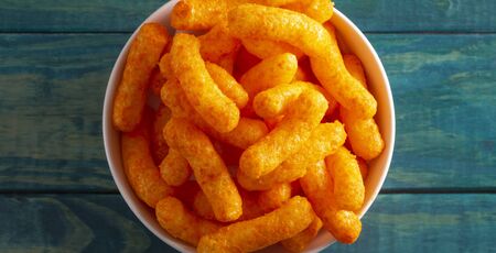 Orange Cheddar Cheese Puffs on a Blue Wood Table
