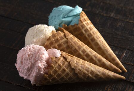 Red White and Blue Ice Cream Cones in a Row on a Wooden Table