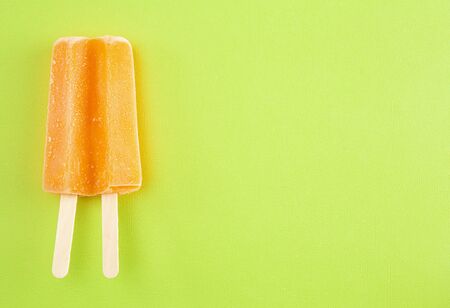 Orange ice on a Bright Green Backgroundの写真素材